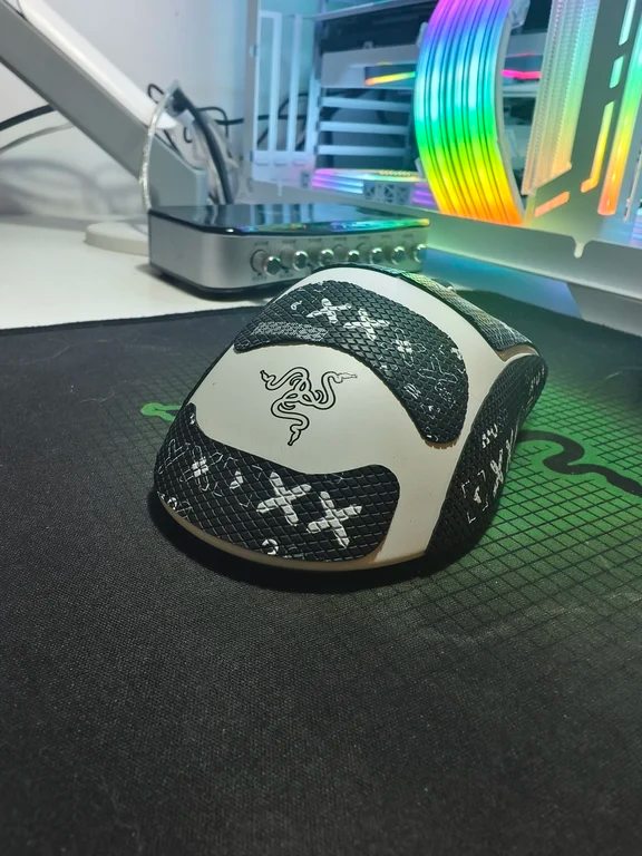 White Razer gaming mouse with custom black grip tape patches on the palm rest and side