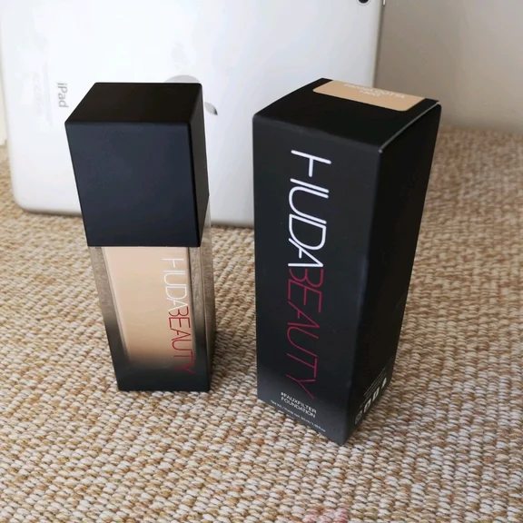 Huda Beauty FauxFilter liquid foundation bottle standing beside its black retail box