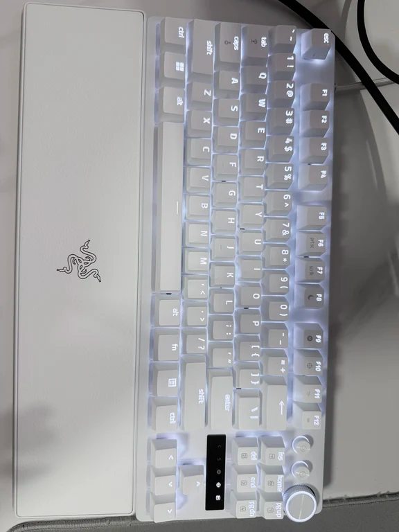White mechanical keyboard with attached wrist rest and top-right rotary knob