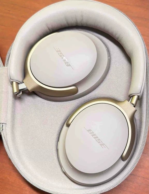 Folded light-beige Bose QuietComfort Ultra headphones nested securely in their custom travel case.