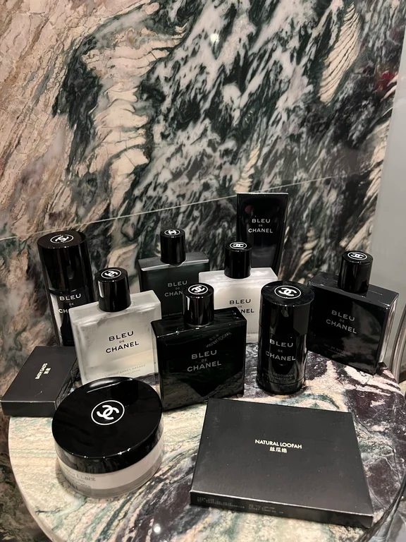 مجموعة متكاملة من منتجات العناية والعطور بلو دي شانيل موضوعة على سطح رخامي