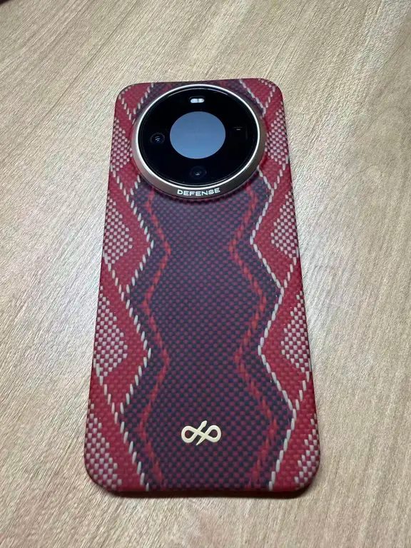 Back of a smartphone protected by a red and navy patterned woven case