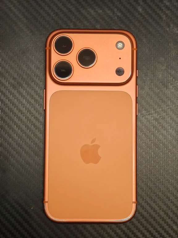 Back panel of an orange iPhone with a large horizontal camera island and triple lenses