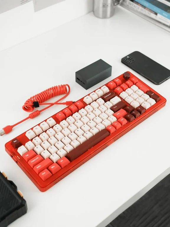 Vibrant red mechanical keyboard paired with cream keycaps and a coiled red cable