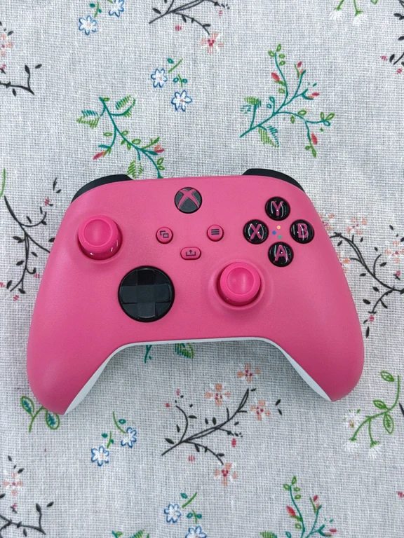 Pink Xbox Series wireless controller displayed on a floral patterned background