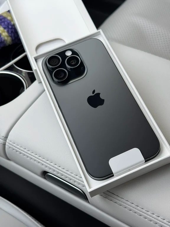 iPhone رمادي داكن في صندوق مفتوح على مقعد السيارة