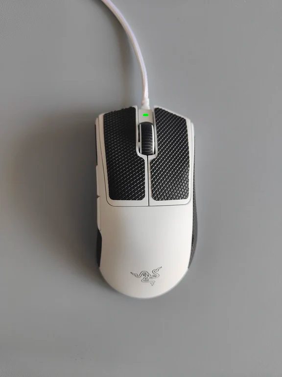 Top-down view of a white Razer wired gaming mouse fitted with textured black grip tapes on the buttons