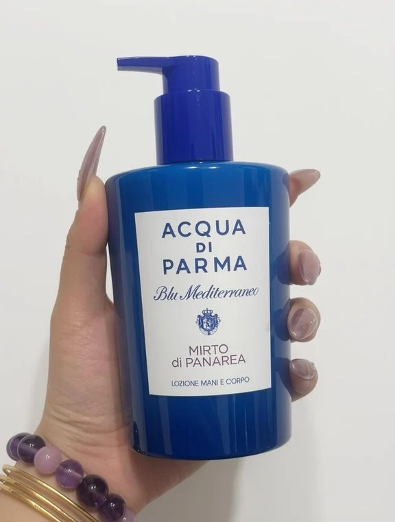 Acqua di Parma Mirto di Panarea blue hand and body lotion pump bottle held in hand