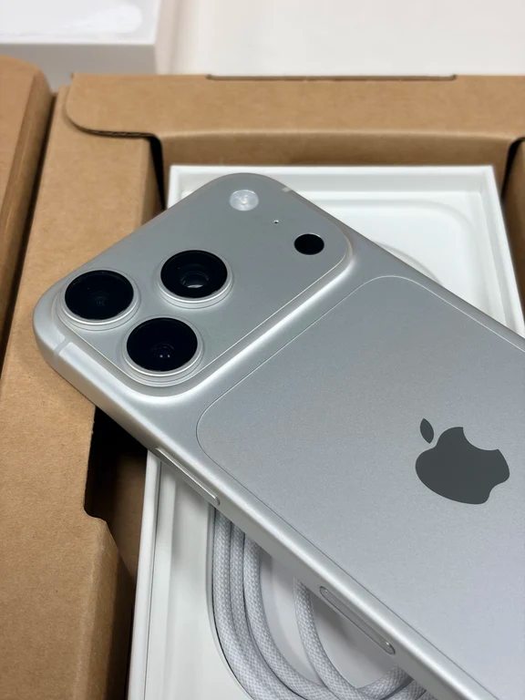 Silver tone iPhone chassis with a redesigned rear camera layout resting inside its open product packaging