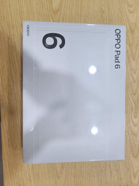 White retail box of an OPPO Pad 6 on a light wooden table.