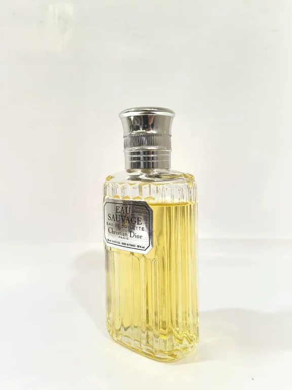A tall faceted glass bottle of Dior Eau Sauvage Eau de Toilette against a white background.