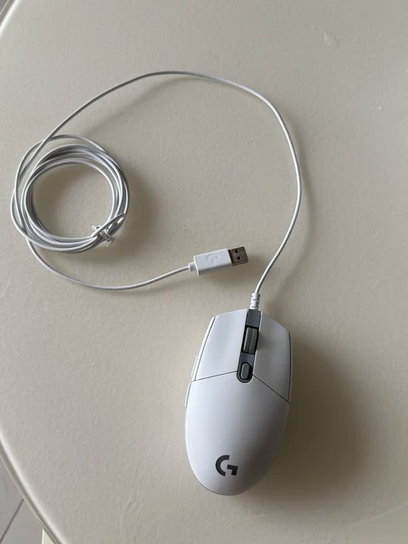 White wired Logitech gaming mouse resting on a clean surface with looped cable
