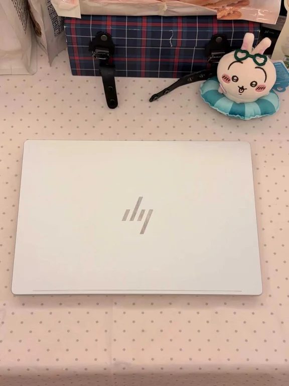 Closed silver HP laptop resting on a polka dot tablecloth